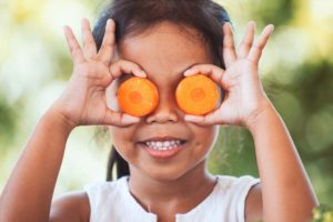 frutta e verdura arancio su occhi bambina