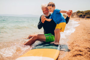 Allenamento-sulla-spiaggia-nonno-e-nipote-che-fanno-surf-tavola-gialla